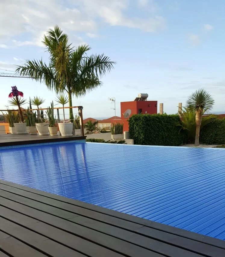 Piscina azul en Tenerife con vistas panorámicas y palmeras alrededor